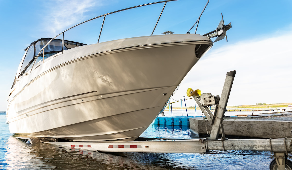 motorboat yacht launching at trailer ramp on lake