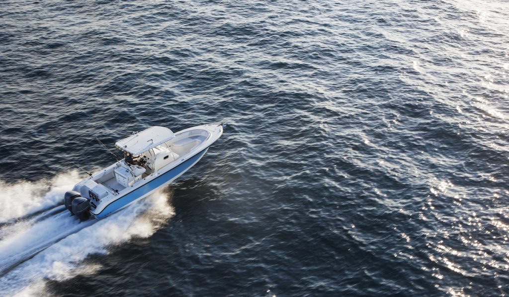 Aerial View Of Couple Driving Speedboat On Sea
