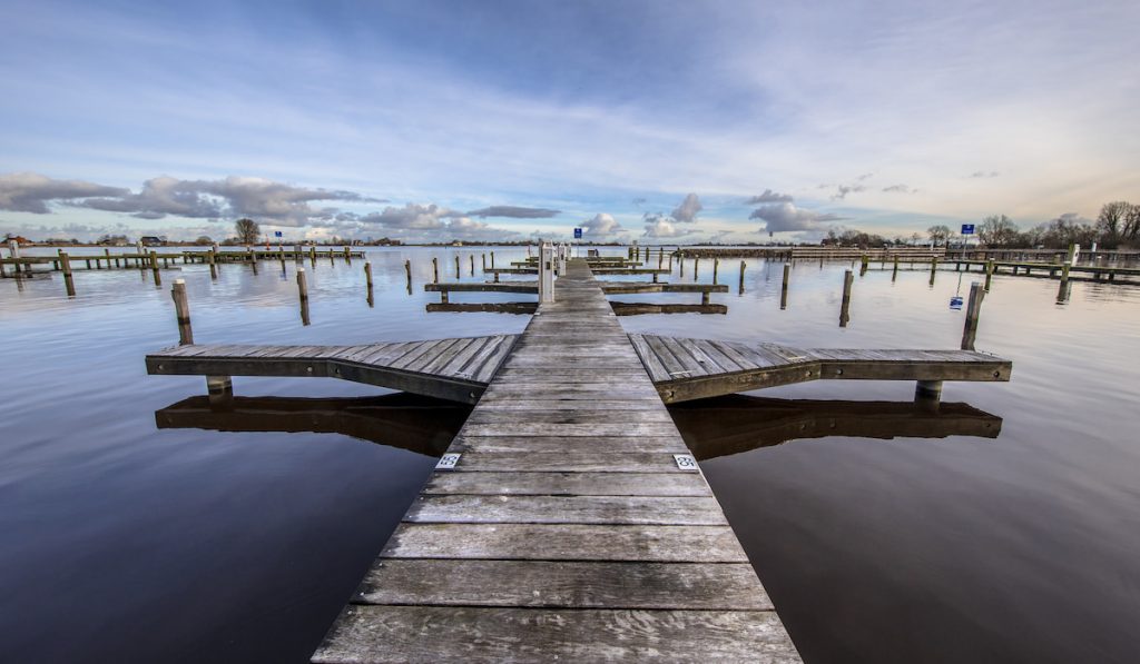 Empty wooden jetty in marina on lake shore