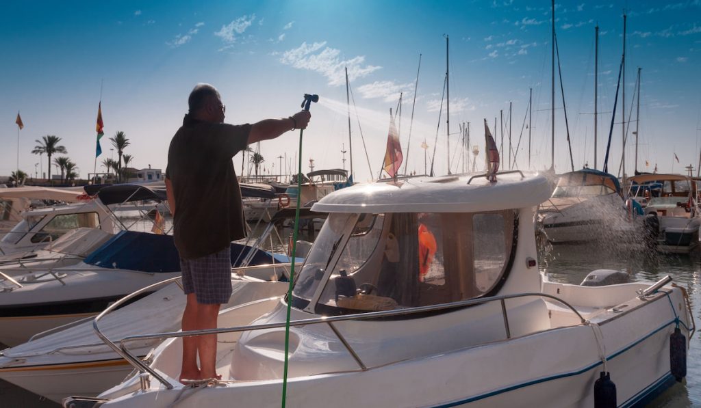 Man washing his boat in port 