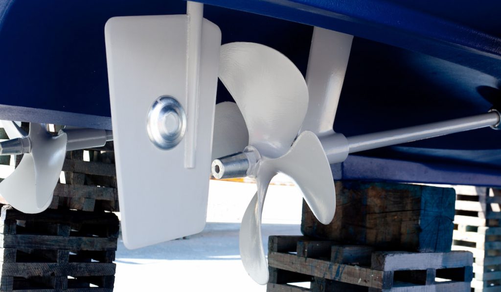 white painted propeller and steering with zinc anodes in blue hull 